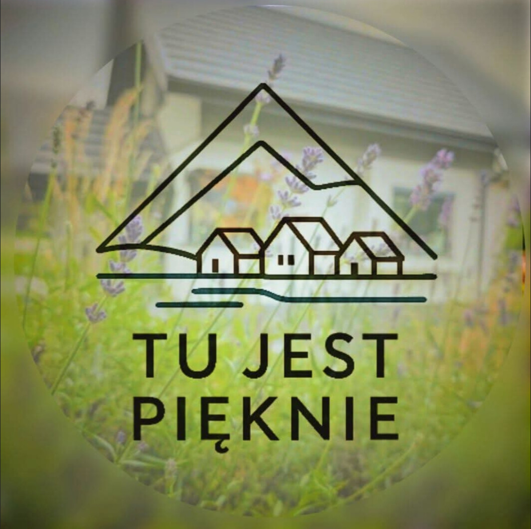 Logo firmy Tu jest pięknie z ilustracją domu i gór na tle ogrodu